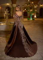 Full-length rear view of the chocolate brown velvet dress showing the elegant off-shoulder V-back profile and the sweeping train adorned with asymmetrical bronze-gold metallic hand-embroidery.