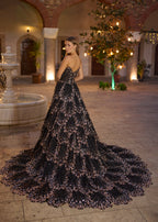 Full-length back view of the black and gold modern evening party dress, highlighting the elegant low-V back cut and the magnificent, wide sweeping cathedral train shimmering with hand-beaded sequins.