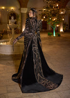 Full-length back view of the black velvet evening dress, highlighting the premium figure-hugging panel structure and the majestic sweeping royal train lavishly embroidered with shimmering metallic motifs.