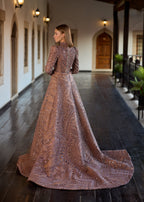 Full-length back view of the hand-beaded rose gold couture gown, highlighting the majestic sweep of the detachable train and the beautiful drapes of the linear sequin patterns.