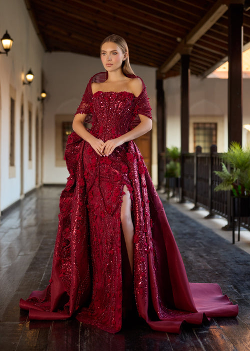 Full-length front view of the burgundy 2-in-1 wedding gown with the structured detachable over-skirt attached, showing the rich satin-lined train and the dramatic thigh slit.