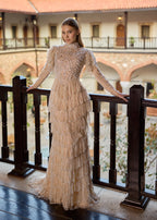 Full-length front view of a majestic champagne-cream haute couture hijab wedding dress, featuring 100% hand-sewn pearl embellishments, a high neck, long sleeves, and a tiered fringe skirt by Sultan Dress.