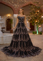 Full-length front view of a modern black and gold henna party dress featuring an asymmetric strapless corset neckline, voluminous A-line skirt, and heavy artisanal hand-beaded sequin work.