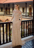Full-length front view of a transformative hand-beaded champagne gown featuring a tiered pearl fringe skirt, detachable sheer long sleeves, and a removable high-collar neck drape by Sultan Dress.