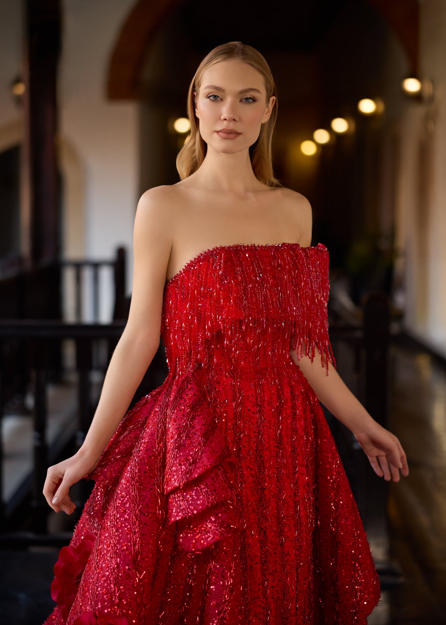 Close-up of the strapless red sequined bodice, showcasing the dense hand-beaded crystal fringes cascading over the neckline of the luxury bridal gown.