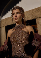 Detailed side-profile view of a custom-made bridal gown showcasing the intricate rose gold beadwork on the corset, halter neckline, and dramatic 3D velvet flower sleeve.