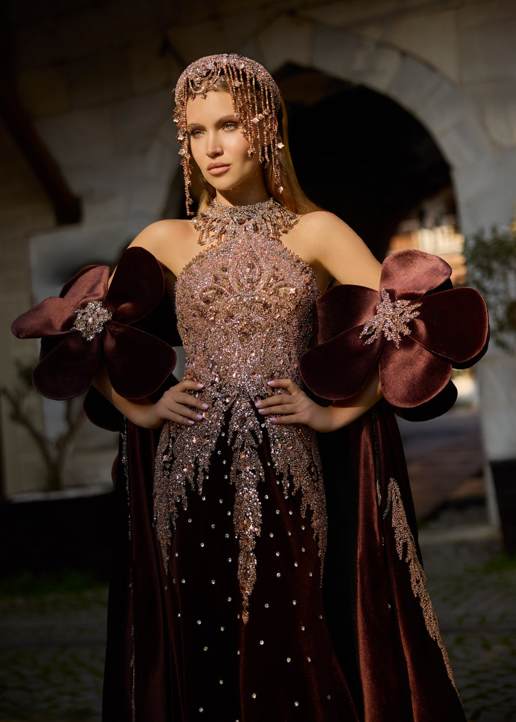 Full-length front view of a majestic deep burgundy velvet bridal kaftan gown with a sparkling hand-beaded corset, dramatic 3D floral arm accents, and a sweeping satin train.