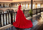 Full-length back view of a luxury 2-in-1 red bridal gown showing the dramatic court train of the detachable ruffle skirt cascading down the balcony.