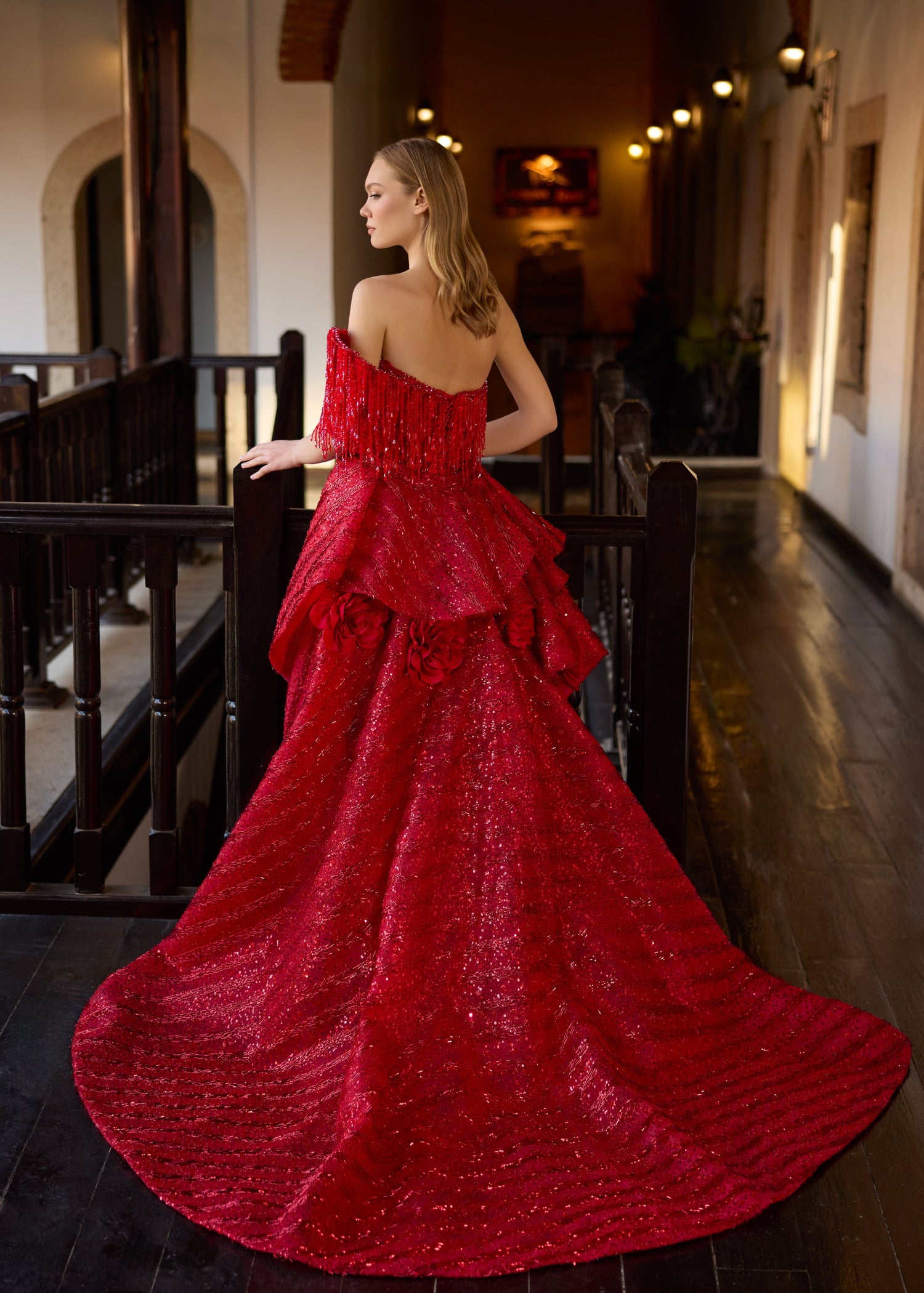 Full-length back view of the red 2-in-1 wedding dress, showcasing the sweeping sequin train, open back, and detailed handmade 3D fabric roses clustered on the detachable skirt.