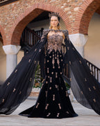 Black velvet mermaid henna dress featuring handmade beadwork, floor-length cape sleeves, and a matching crown.