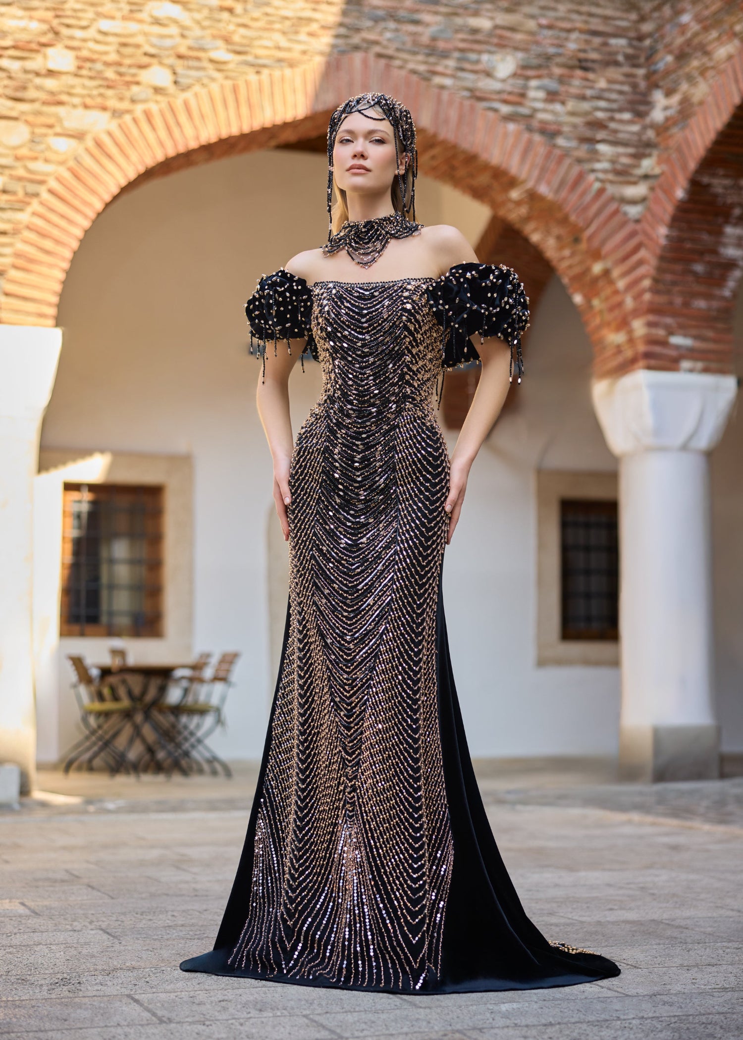 Luxury black velvet mermaid henna dress featuring intricate handmade gold and black beadwork, off-the-shoulder puff sleeves, detachable overskirt, handcrafted necklace, and statement crown.