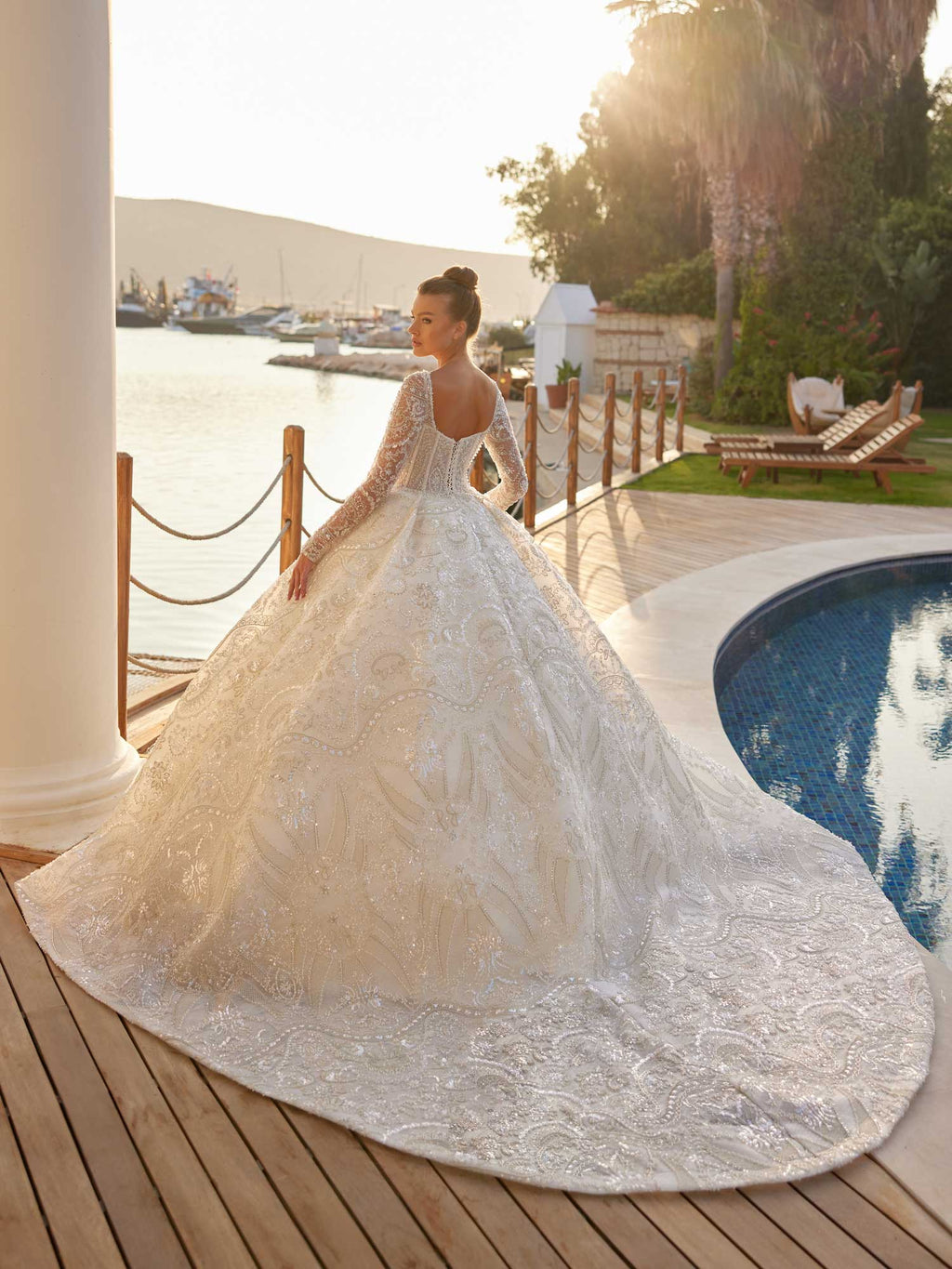 Rear view showing the open square back and dramatic cathedral train on the elegant floral lace corset Turkish wedding dress by Sultan Dress.