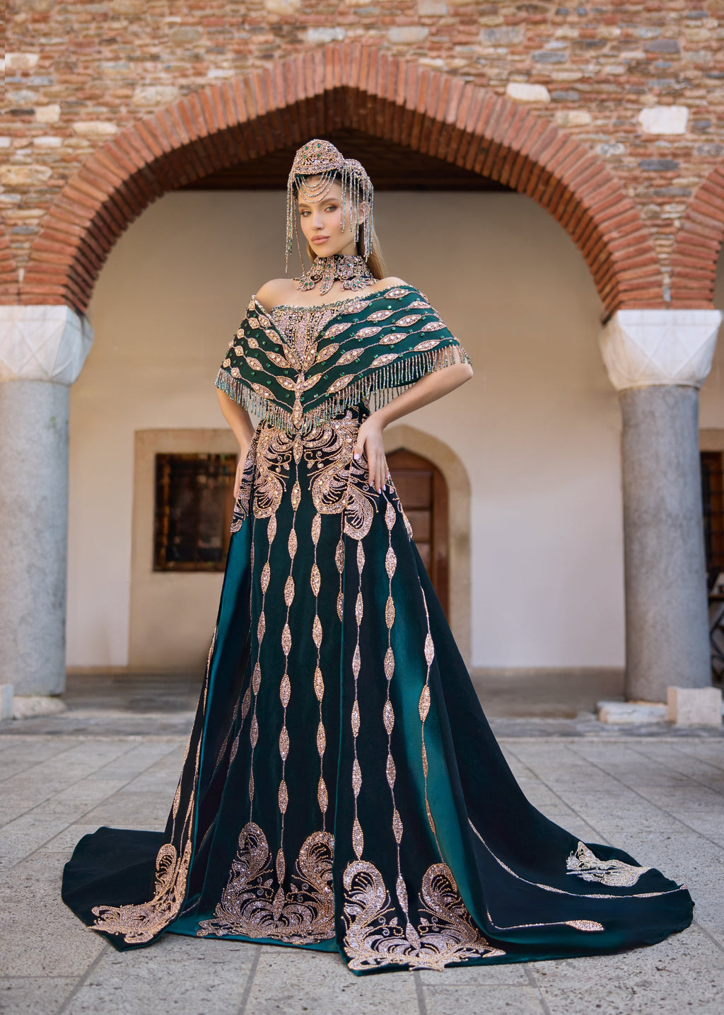 Emerald green luxury henna dress featuring extensive handmade beadwork, gemstone embellishments, a detachable overskirt, and a handcrafted crown and necklace set.