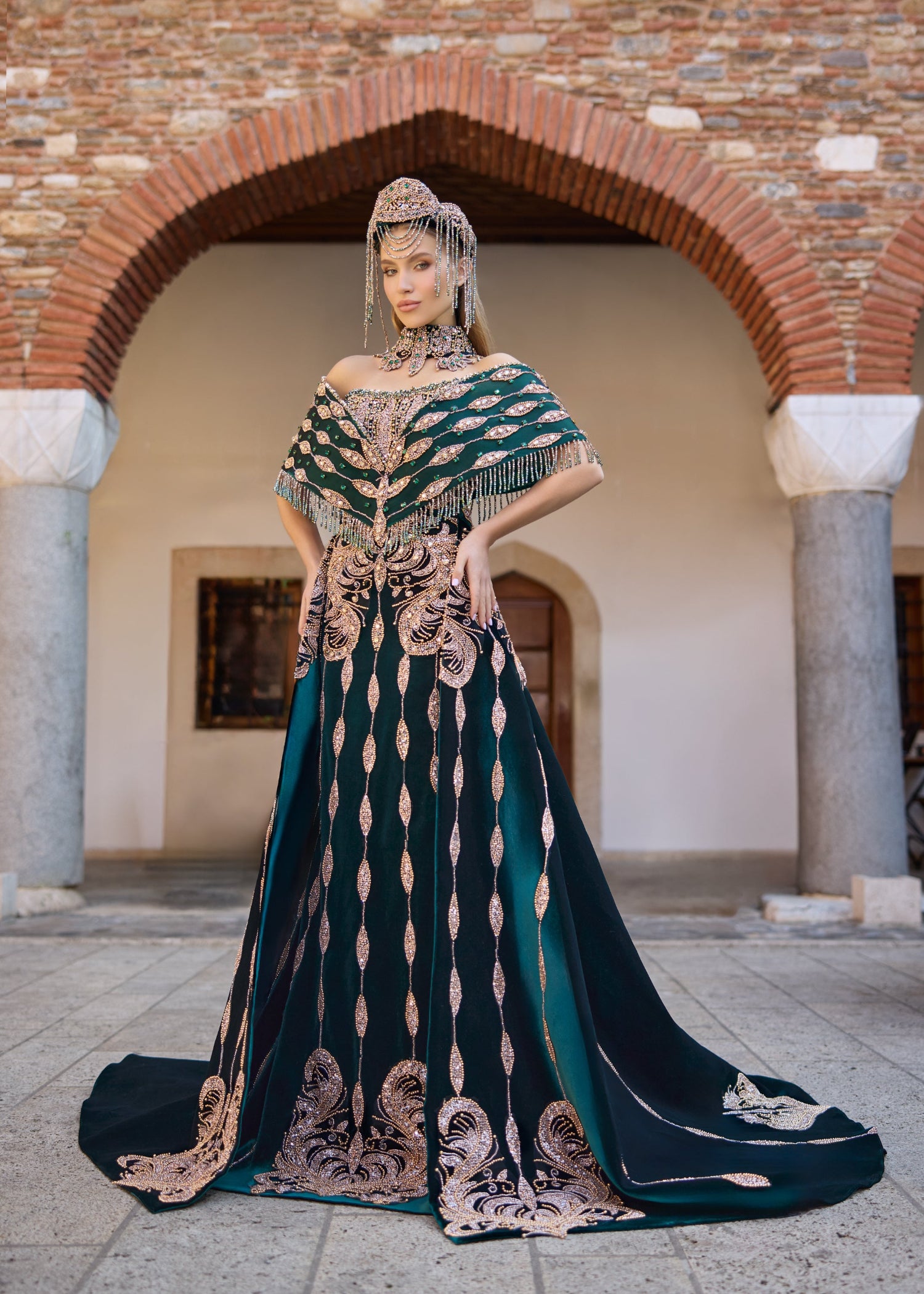 Emerald green luxury henna dress featuring extensive handmade beadwork, gemstone embellishments, a detachable overskirt, and a handcrafted crown and necklace set.