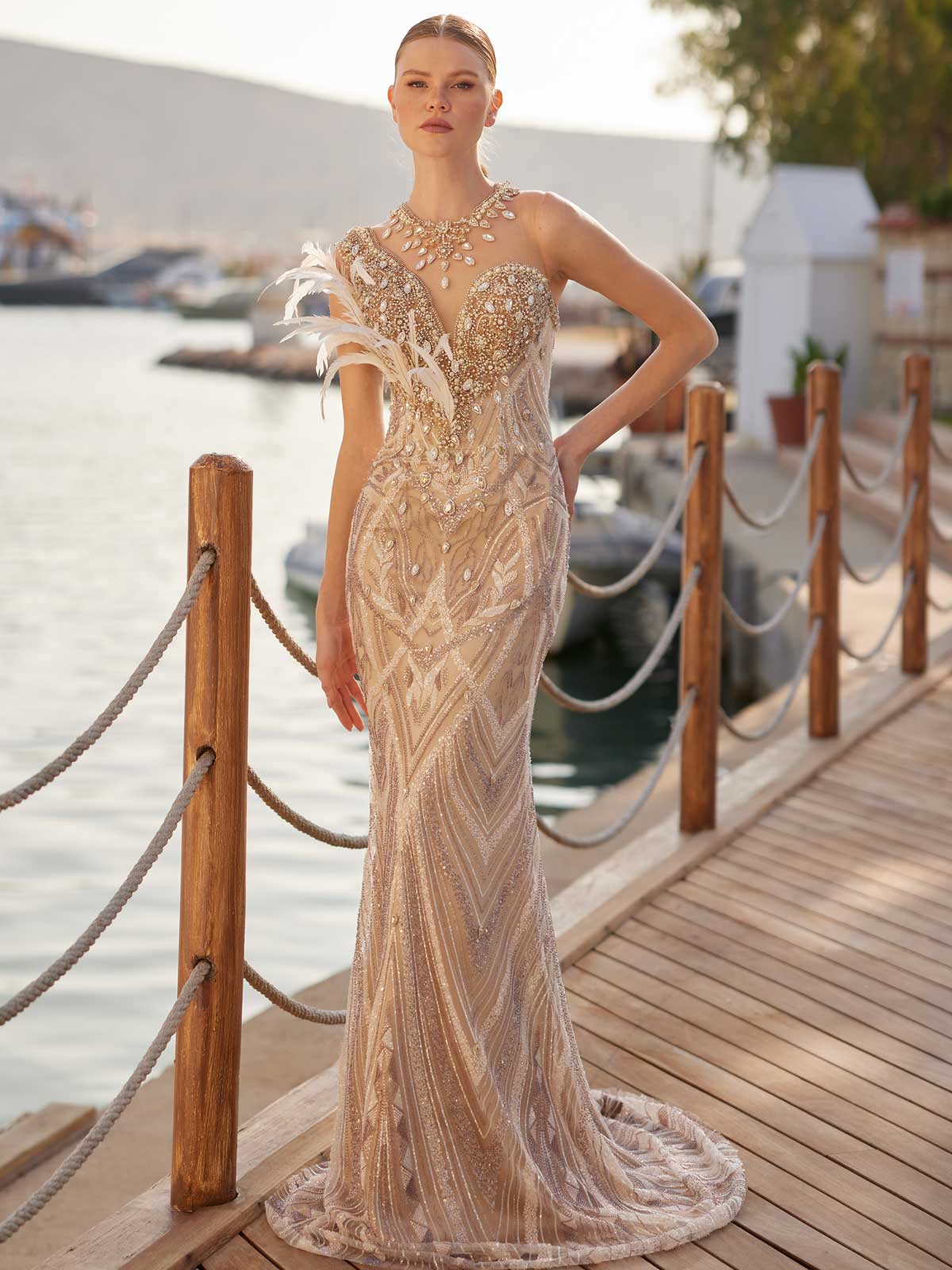 Close-up of hand-beaded rhinestones, pearls, feather appliques, and satin overskirt waistband on the nude evening dress.
