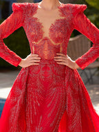 Close-up of the plunge illusion neckline, crystal bead pattern, and structured shoulder sleeves on the red evening dress.