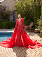 Full-length front view of the fitted red beaded formal gown paired with its voluminous detachable tulle overskirt train.