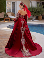 Rear view showing the sweeping red velvet train with central gold glitter leaf embroidery on the henna gown by Sultan Dress