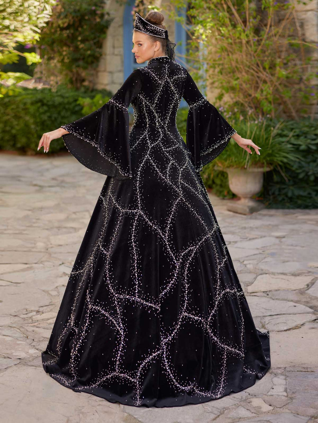 Rear view showing the high collar, beaded velvet lattice pattern, and flared bell sleeves on the black henna kaftan gown.
