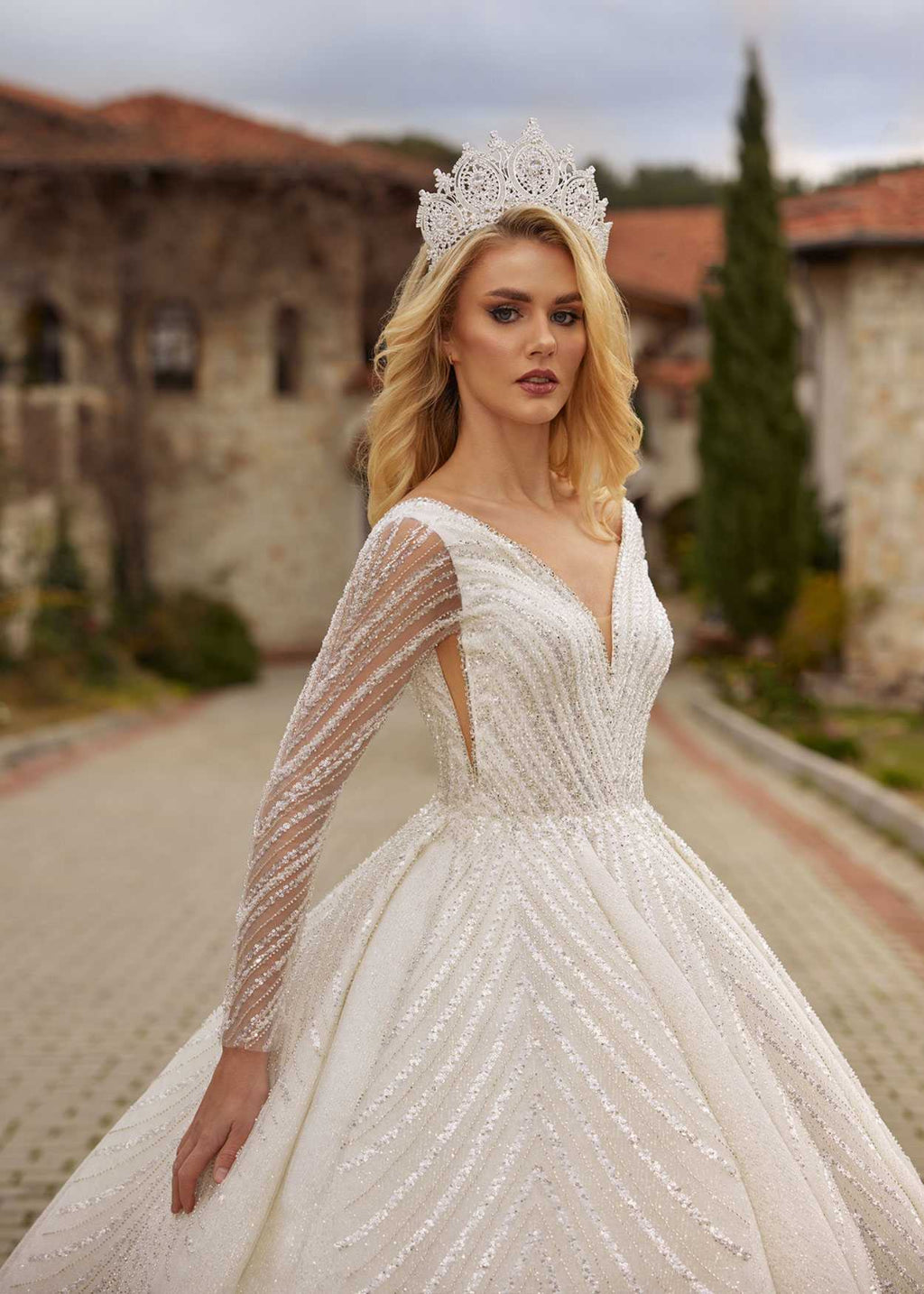 buy Front view showing the beaded sheer illusion long sleeves and V-neckline of the sparkle ball gown by Sultan Dress.