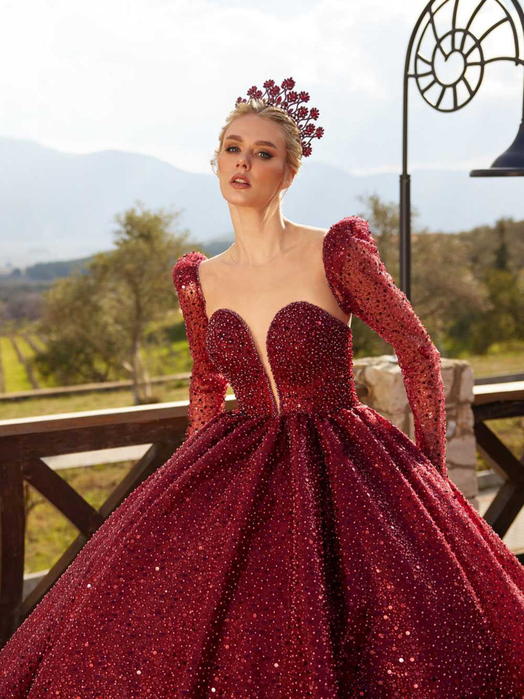 Full-length front view of the burgundy sequin ball gown featuring a plunging sweetheart neckline and long sleeves by Sultan Dress.