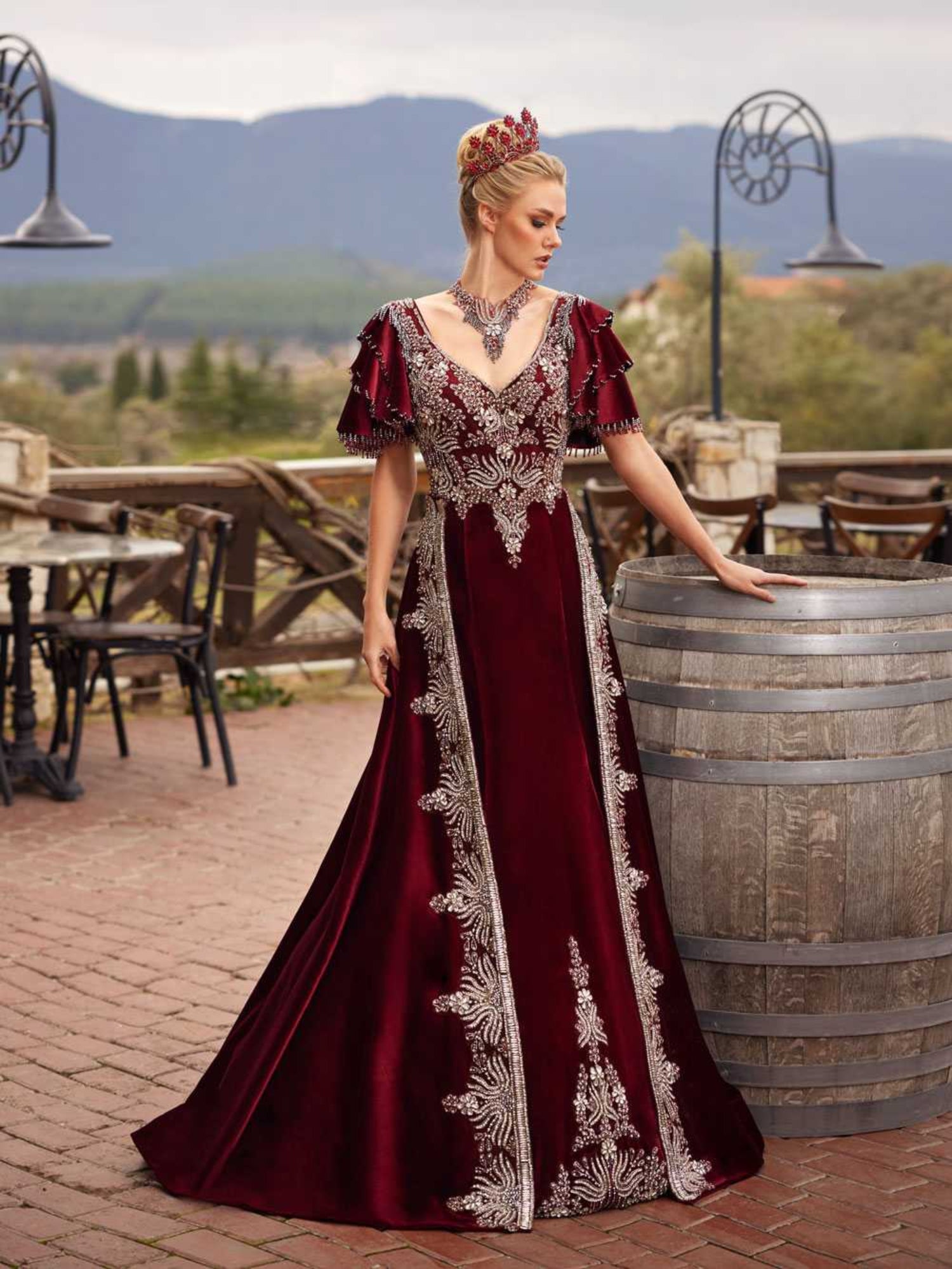 Rear view showing the deep V-back, silver embroidery, and sweeping train on the burgundy velvet Turkish kaftan gown by Sultan Dress.