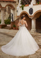Rear view showcasing the open V-back corset and shimmering cathedral tulle train without sleeves attached.