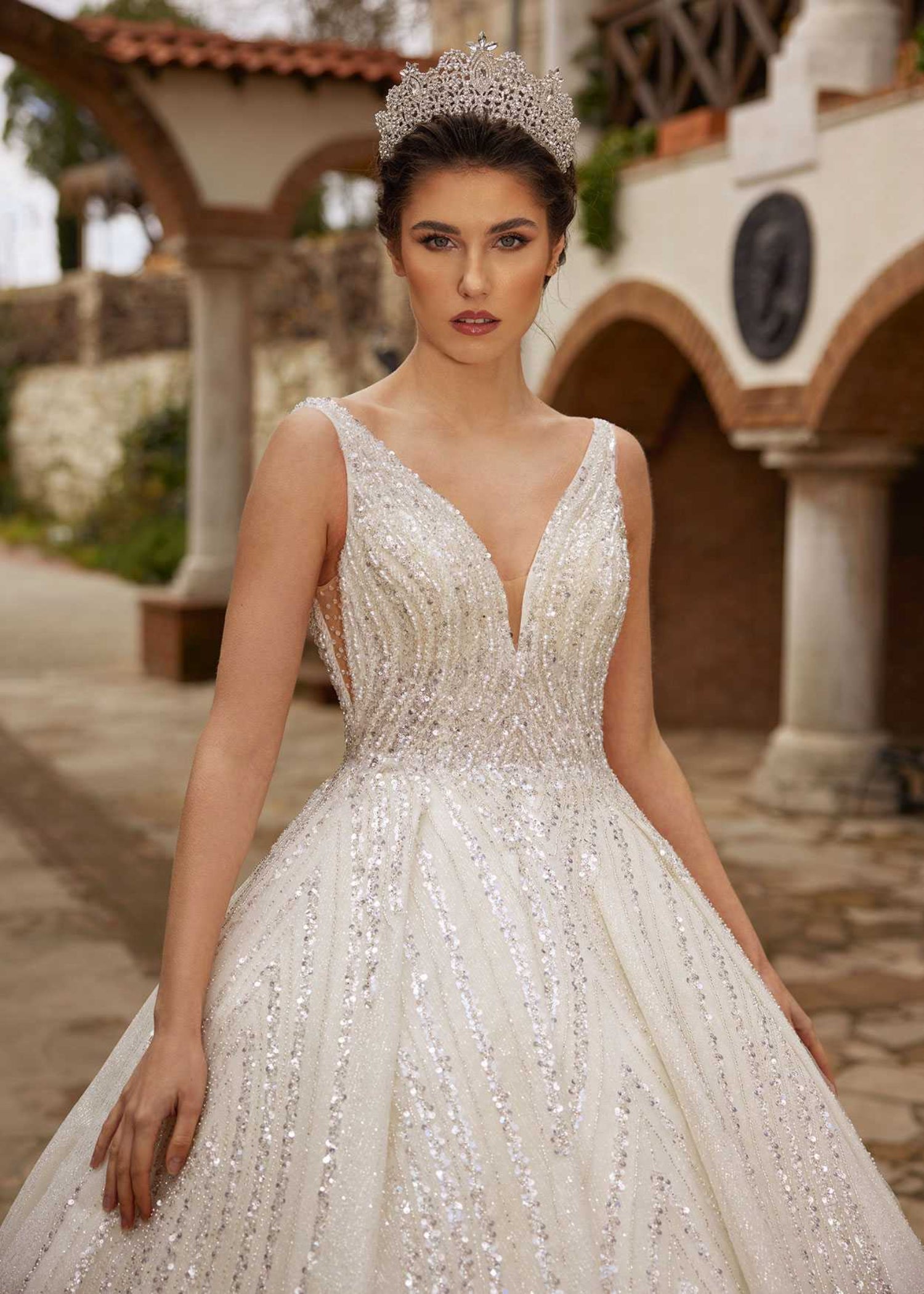 Front view showing the deep V-neckline and cascading geometric sequin embellishments on the sparkle ball gown by Sultan Dress.