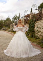 Rear view showing the lace-up corset back, detachable tulle puff sleeves, and wavy sparkle pattern train of the ball gown by Sultan Dress.