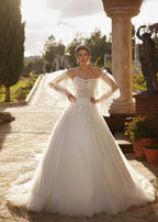 Front view highlighting the sheer floral lace corset bodice and dramatic detachable tulle puff sleeves with pearl button cuffs.
