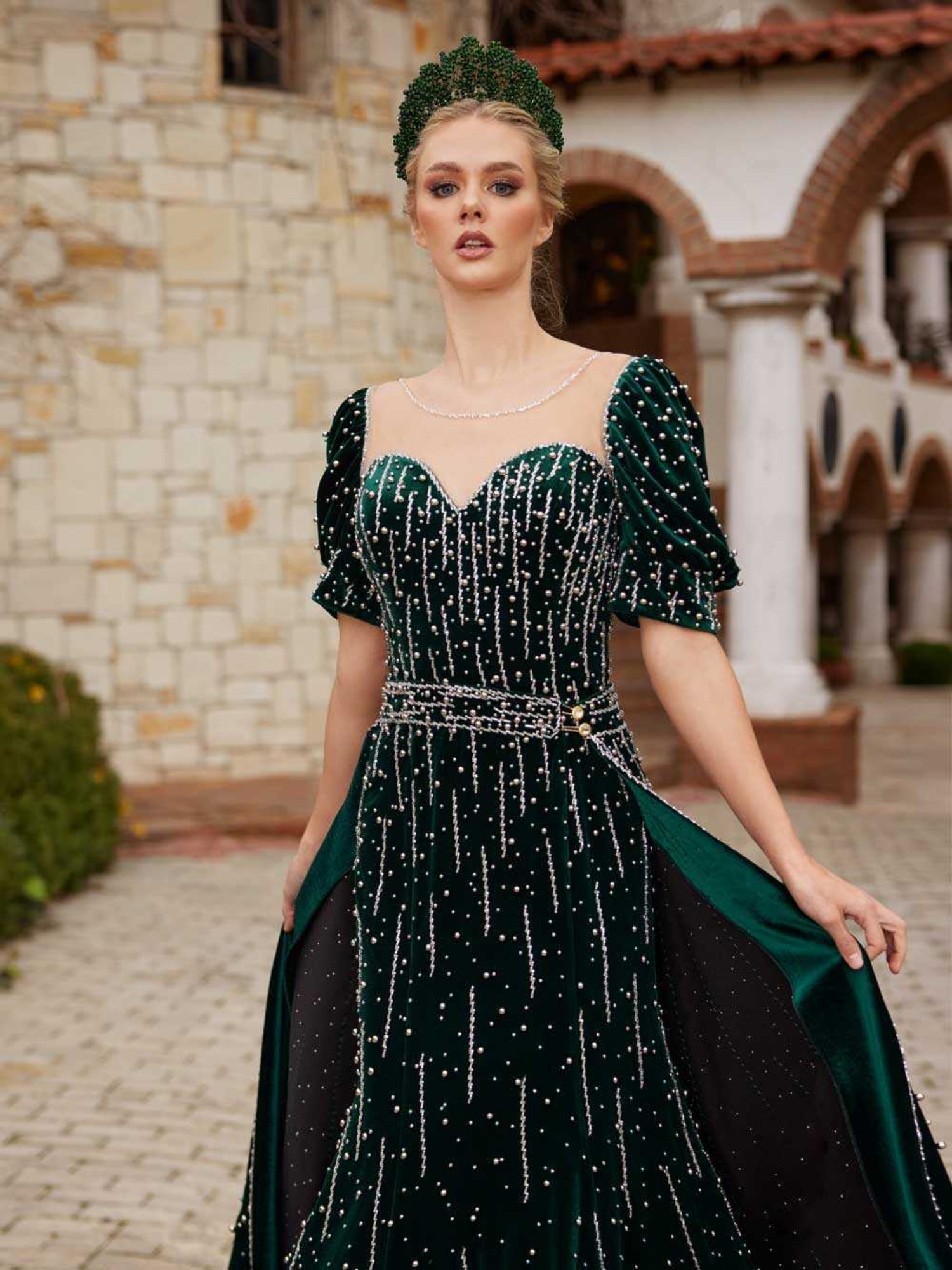 Close-up of the handcrafted pearl and crystal embroidery, sweetheart neckline, and puff sleeves on the emerald velvet dress.