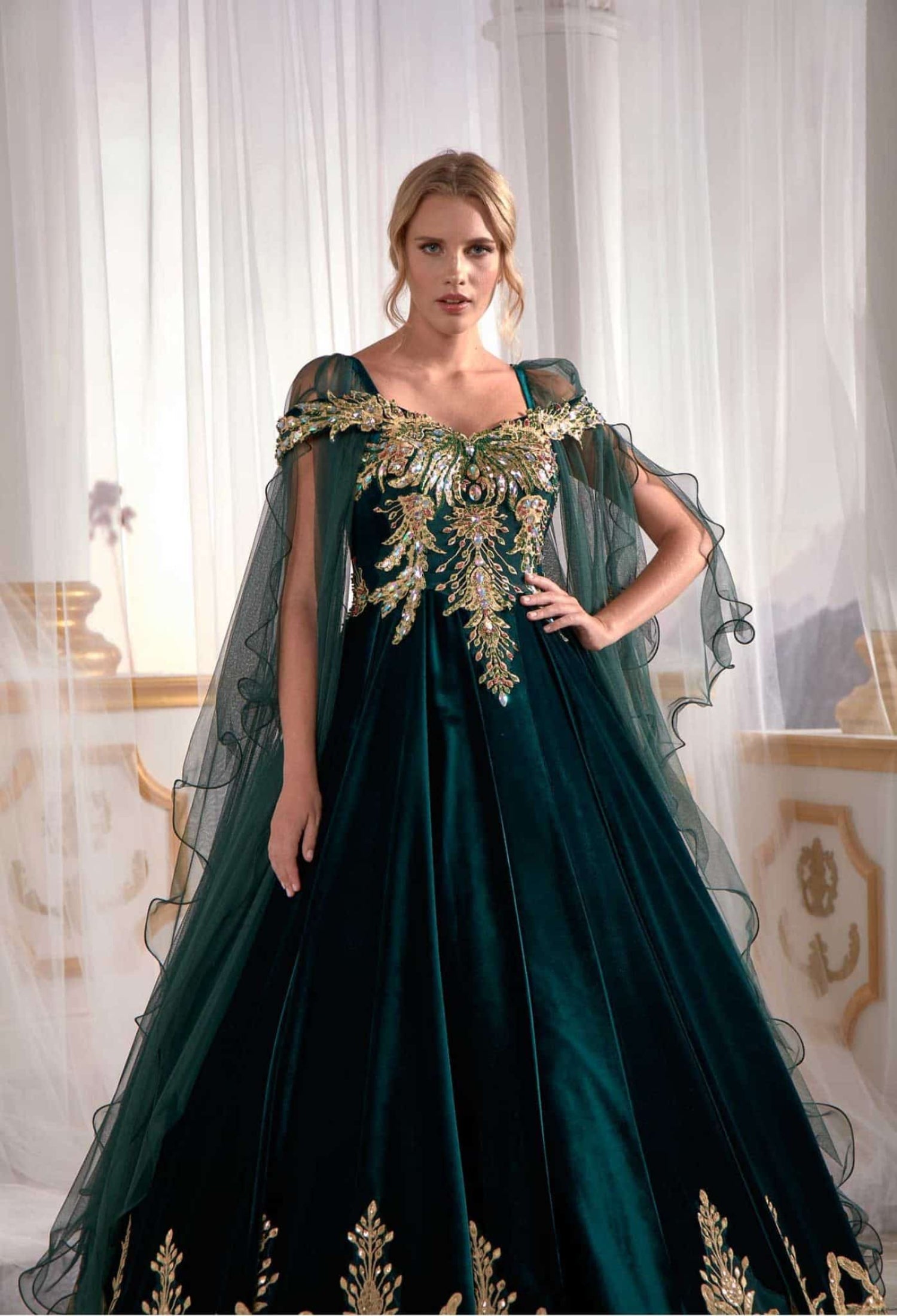 Close-up detail view of the intricate metallic gold embroidery on the emerald green velvet maxi gown.