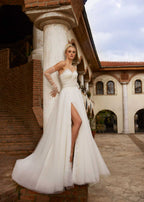 Side profile view highlighting the dramatic high leg slit and airy tulle skirt movement of style 1206.