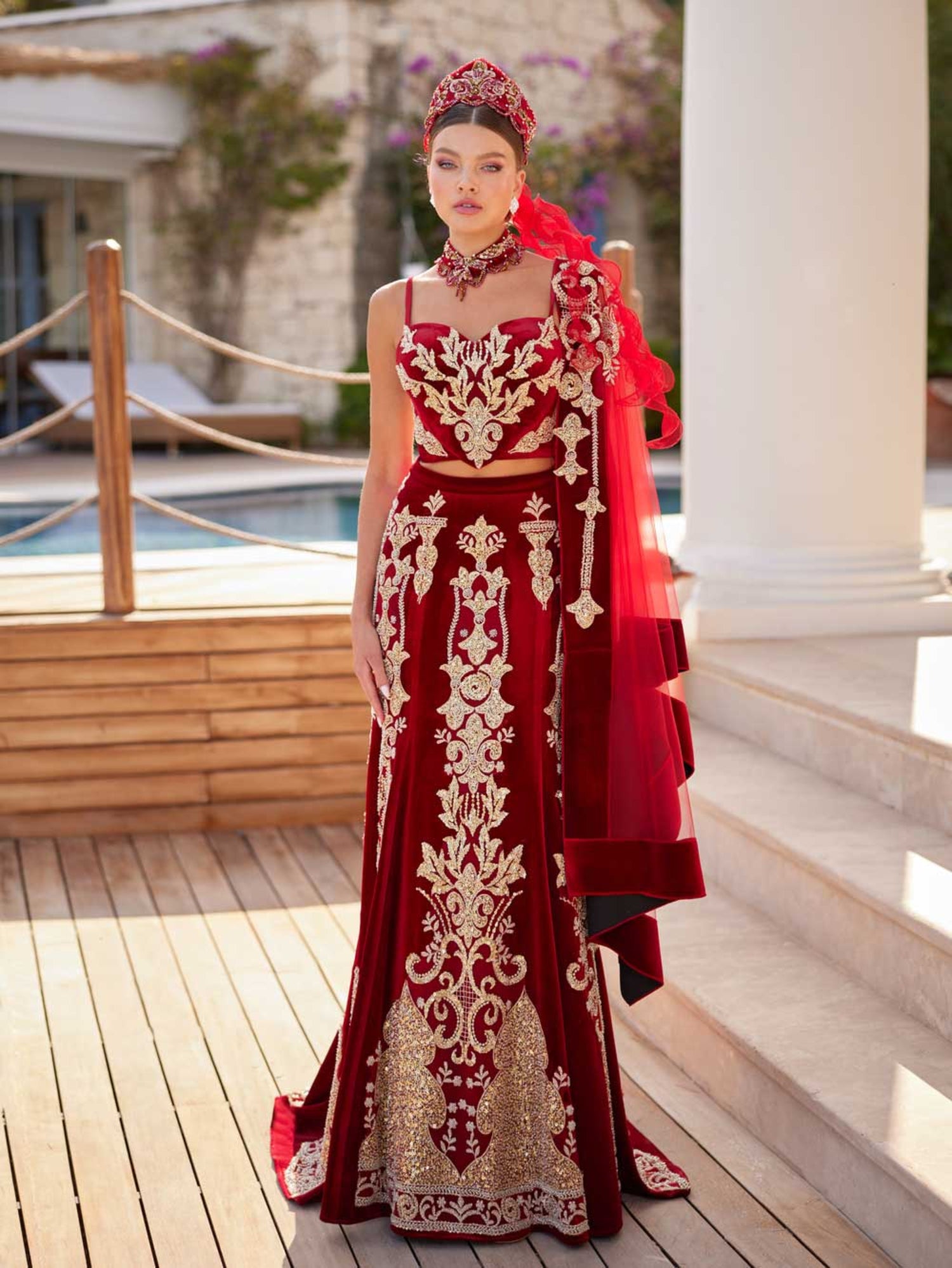 Front view of the two-piece red velvet Henna dress featuring gold sequin bralette top, embellished long skirt, shoulder drape veil, and matching crown by Sultan Dress.