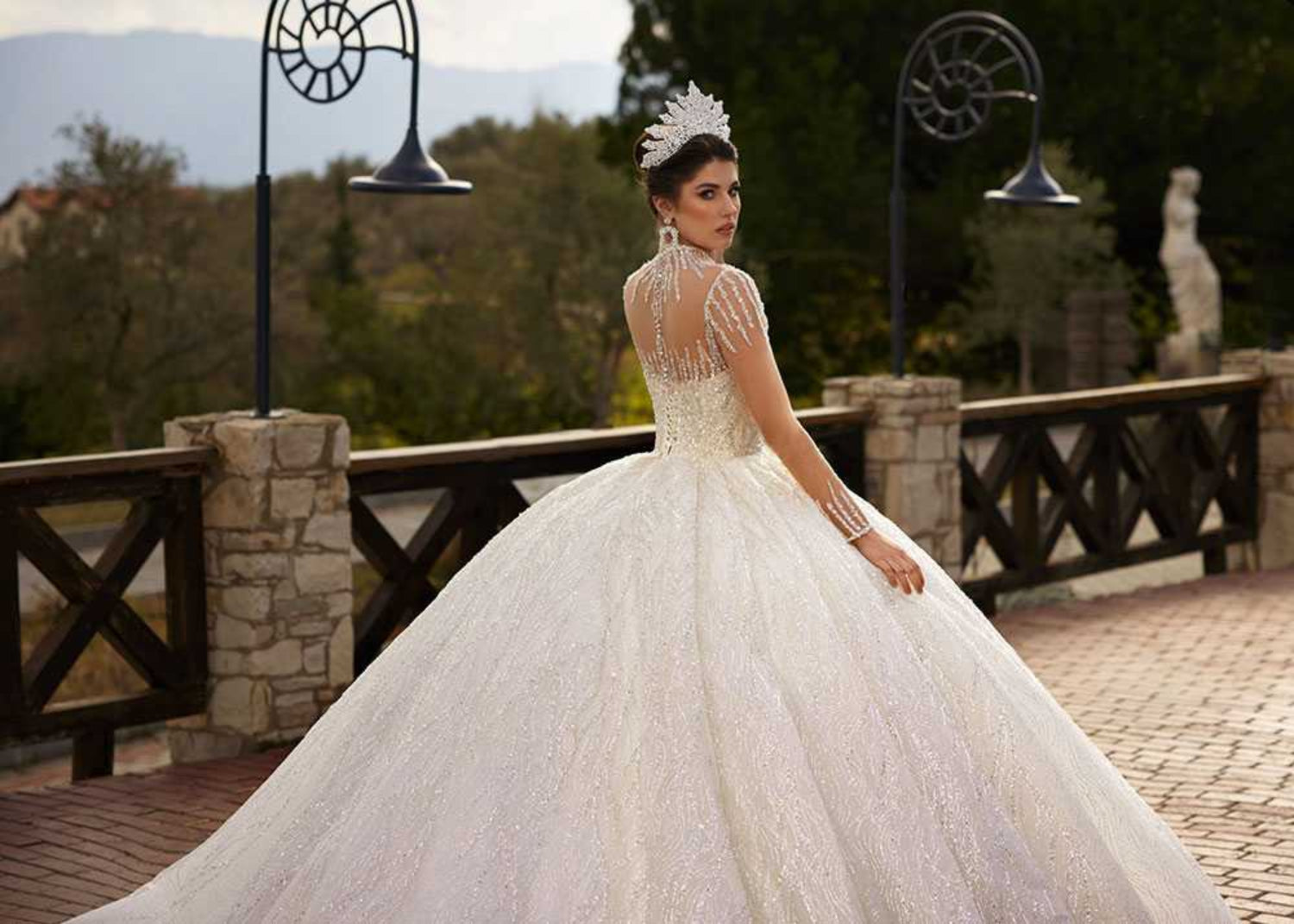 Side and rear view showing the sheer long sleeves, high neck detail, and voluminous glitter tulle ball gown skirt.