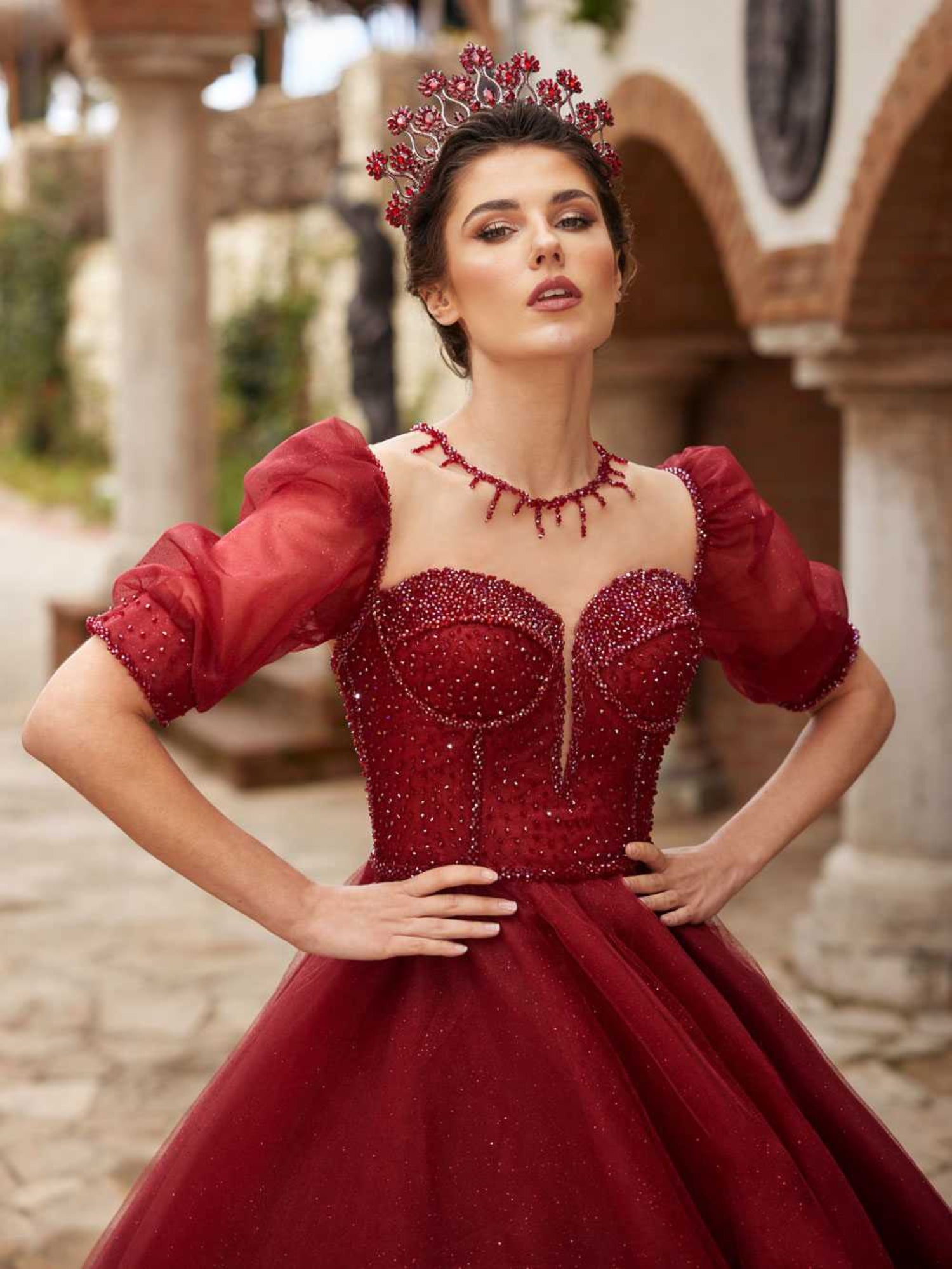 Close-up of the handcrafted maroon crystal beadwork on the sweetheart bodice and organza puff sleeve cuff.
