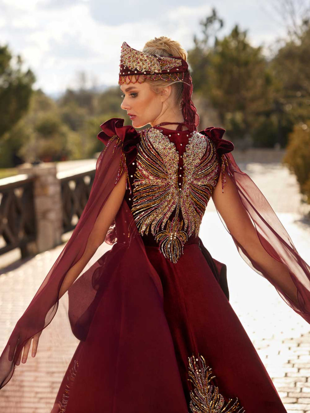 Close-up of the handcrafted colorful crystal beaded back motif and gold lace accents on the maroon velvet bridal Henna gown.