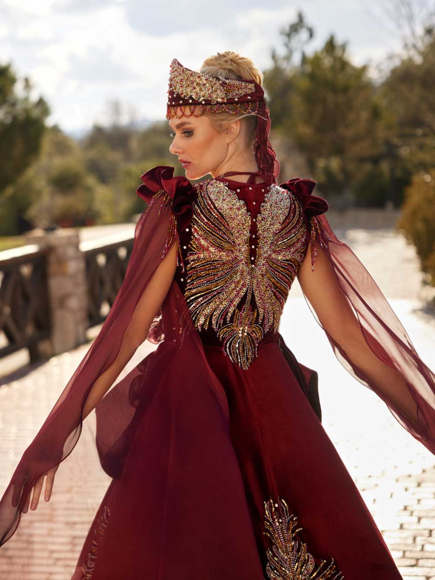 Close-up of the handcrafted colorful crystal beaded back motif and gold lace accents on the maroon velvet bridal Henna gown.