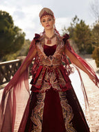 Front view of the maroon velvet Henna kaftan gown featuring gold embroidery, sweetheart neckline, beaded high neck collar, and crown headpiece.