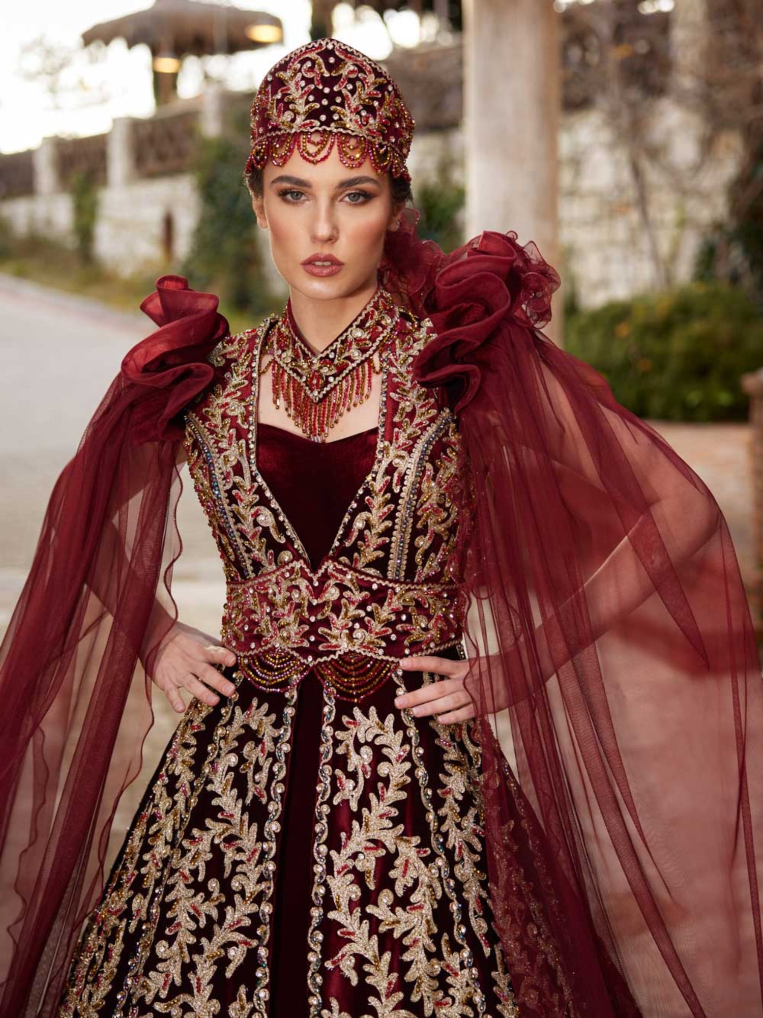 Close-up of the handcrafted gold sequin leaf lace, sweetheart neckline, and beaded collar on the maroon velvet kaftan gown.