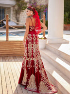 Rear view showing the gold filigree embroidered back of the skirt, red tulle veil attachment, and crown accessory on the red velvet Henna dress.