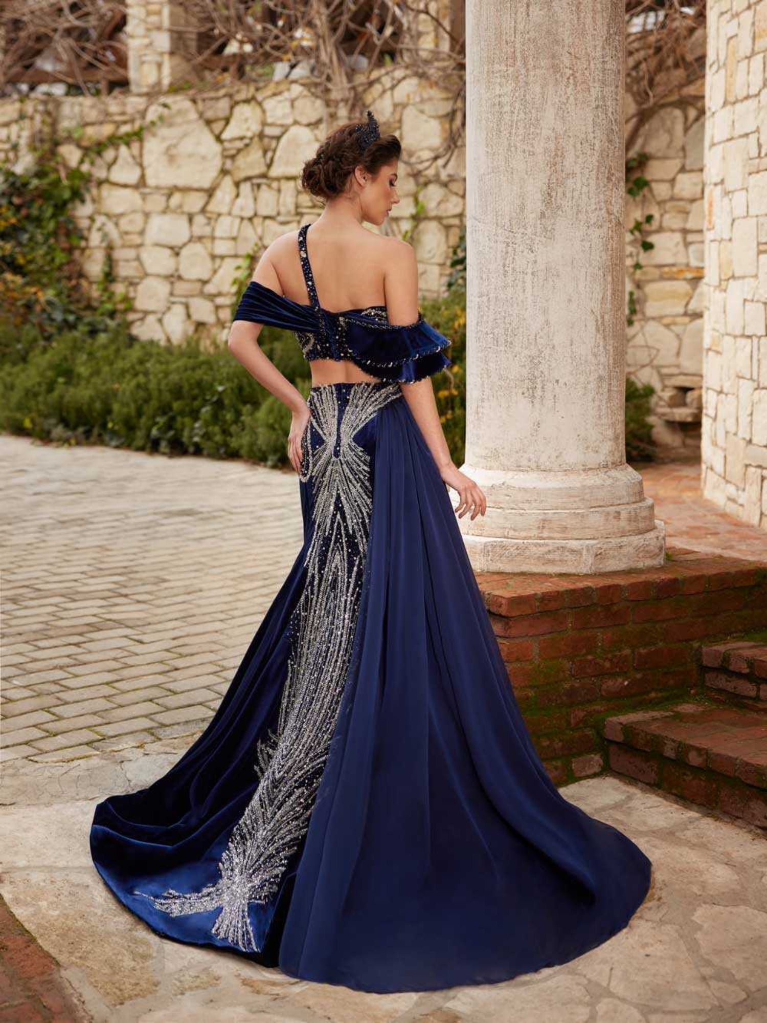 Rear view of the royal blue velvet mermaid dress featuring hand-beaded silver crystal back detailing and flowing side chiffon train by Sultan Dress.
