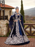 buy Front view of the navy blue velvet bridal caftan gown featuring heavy silver sequin embroidery, bell sleeves, and high-neck collar by Sultan Dress.