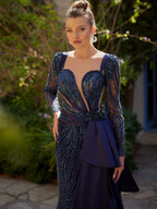 Close-up of the handcrafted navy blue sequin lines, sheer mesh sleeve, and waist-tied satin drape on the long formal dress.