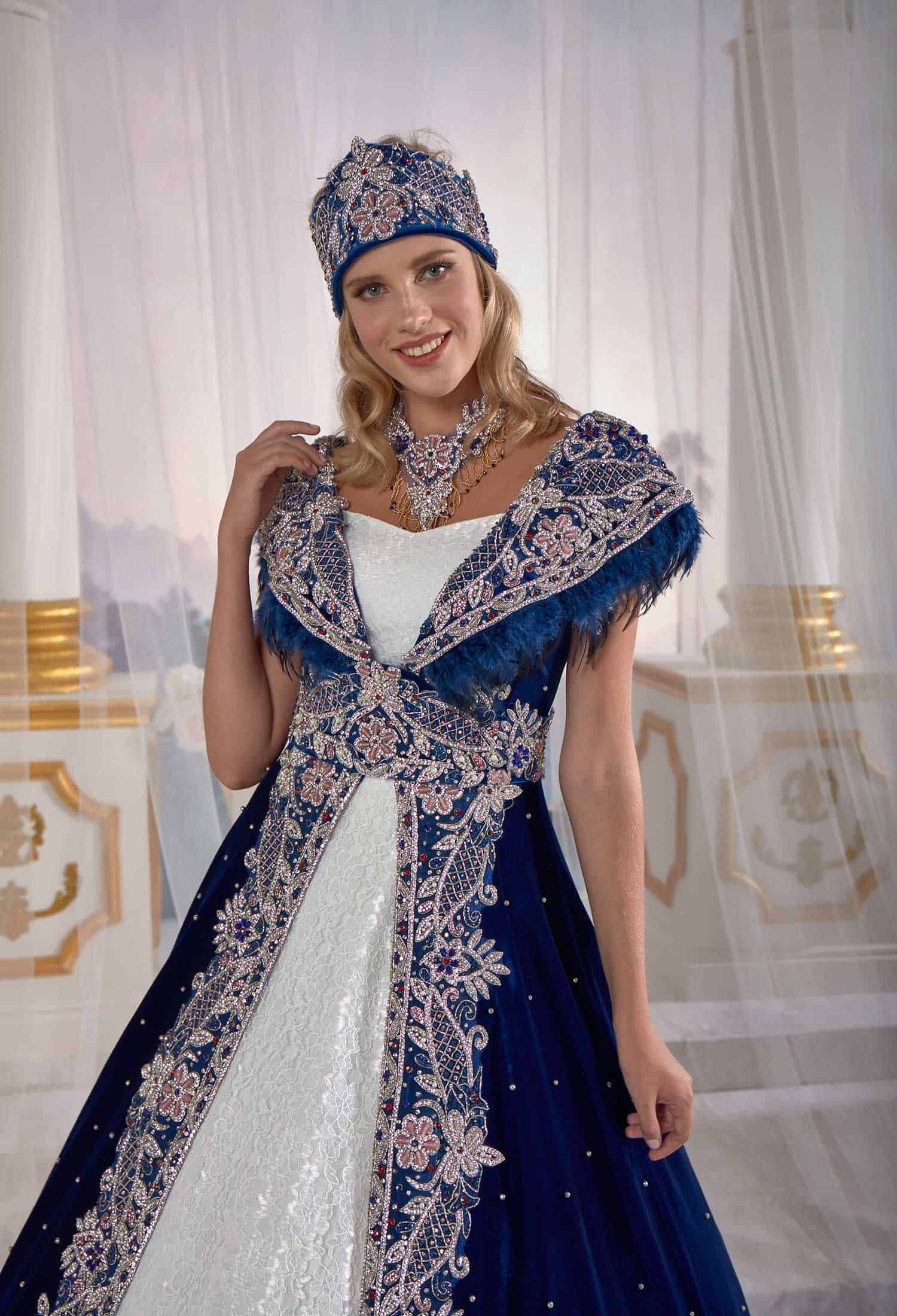 Rear profile displaying the graceful drape and floor-length train of the red and navy velvet embellished caftan dress.