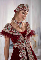 Close-up detail view of the artisan delicate beadwork and soft drape velvet texture on the red and navy caftan gown.
