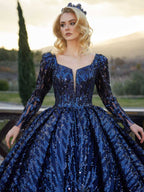 Full-length front view showing the long sleeve heavily sequined royal blue ball gown with a plunge neckline by Sultan Dress.