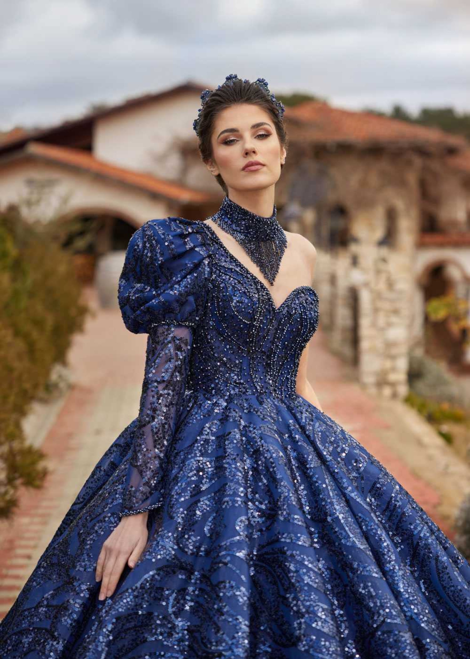 Full-length front view showing the asymmetrical one-shoulder puff sleeve, neckband accessory, and sparkling sequin ball gown skirt by Sultan Dress.