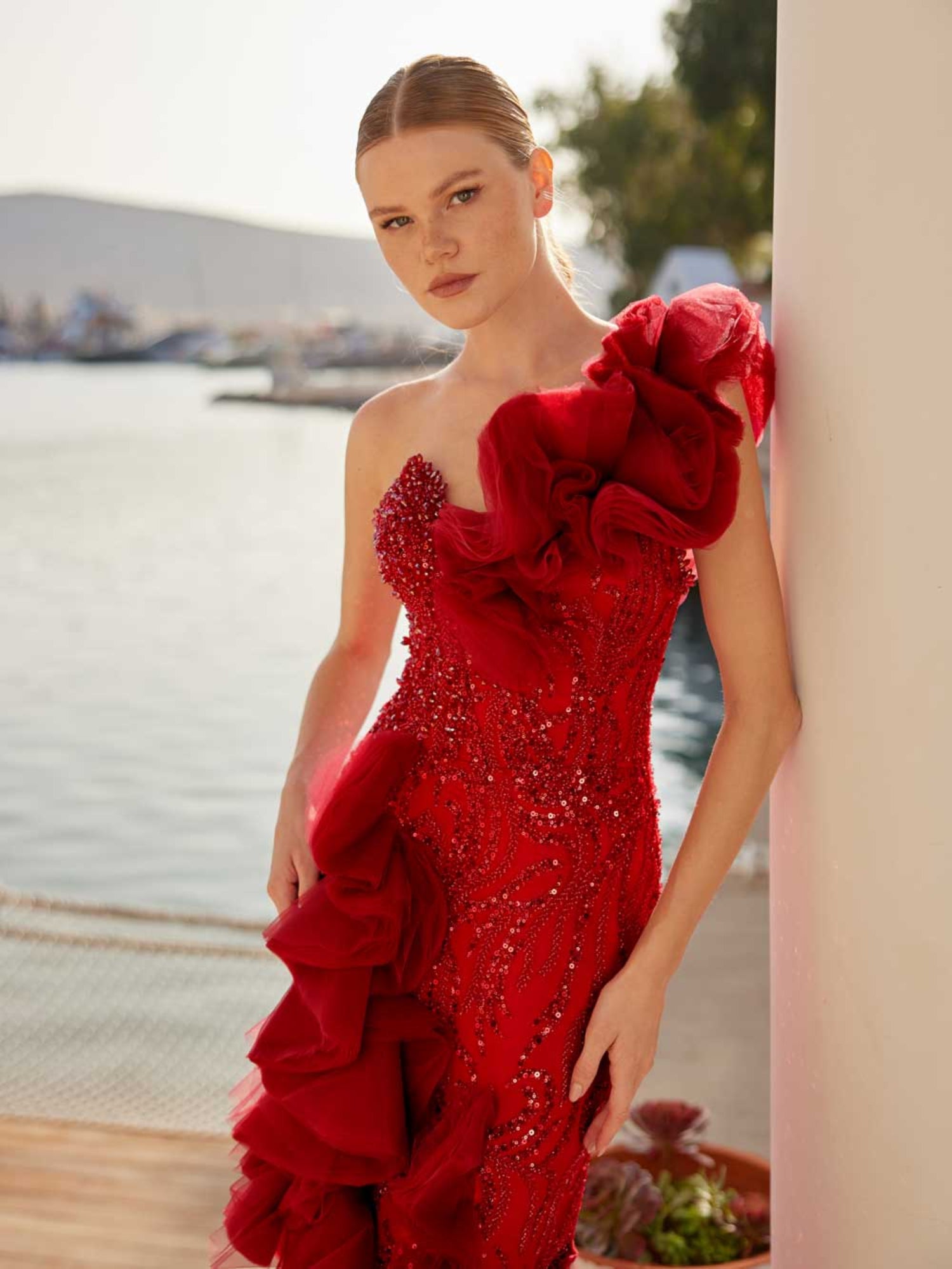 Close-up of the handcrafted red crystal beadwork and hand-sculpted tulle rose shoulder trim on the corset dress.
