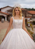 Rear view showing the low V-back lace-up corset and sparkling cathedral train of the ball gown wedding dress.